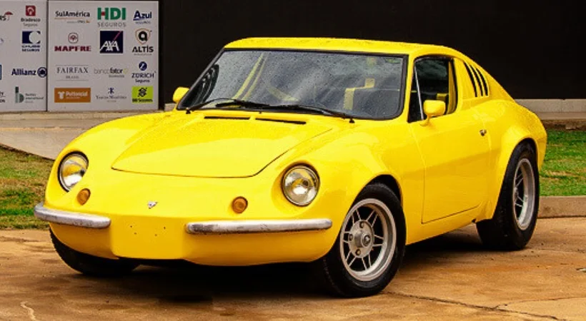 Carro esportivo amarelo estacionado na frente da fachada preta da oficina Pit Stop
